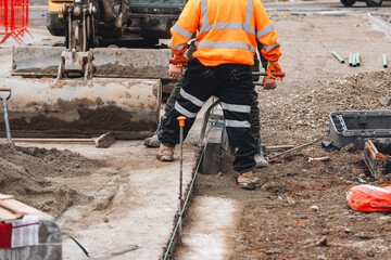 Construction workers laying new kerb stone during road construction