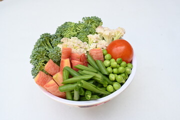 Vibrant medley of fresh vegetables. Features broccoli, cauliflower, tomatoes, Carrot, green beans, and peas. colourful vegetables of spring time, Its good for health. colorful display.