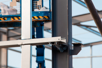 Construction workers assembling steel framework for a new building under clear blue sky in a busy urban area during daylight hours