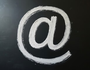 At sign hand-drawn chalk on blackboard. Isolated electronic mail symbol at symbol. Contact, communication, cyberspace concept, email, web, internet address.