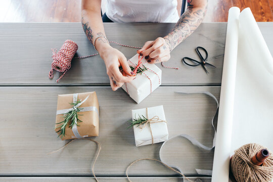 Overhead view of young girl wrapping Christmas presents in natural papers and twine