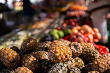 pineapples and other fruit and veg in the morning light at the markets