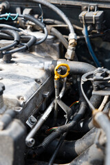 Yellow engine oil dipstick oon the old car motor. Concept for the car service.