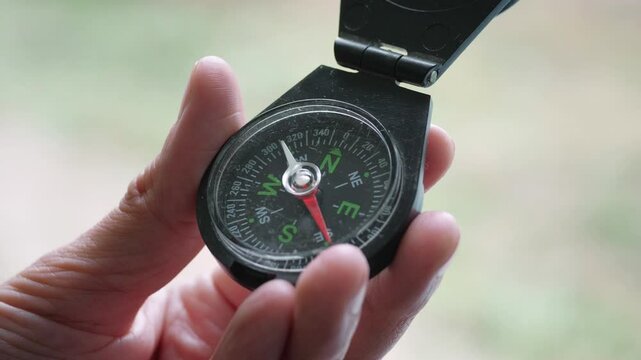 A purposeful and adventurous mood is captured as a hand holds a compass, clearly showing the needle pointing towards North East, suggesting direction, exploration, or decision-making