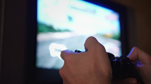 An engaged and immersive mood is captured as hands expertly manipulate a game controller, with the blurred action of a video game visible on an older television screen in the background