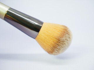 Large blush brush with orange-tinted bristles on white surface