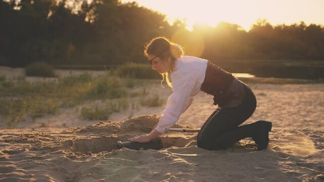 silhouette real person hands digging up treasure with shovel taking brown chest out of sand pit. Fantasy woman pirate finds treasure wooden box old style full rich jewelry. Nature shiny sun light 4k.