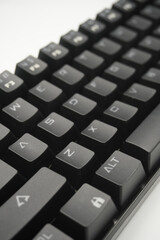 A mechanical keyboard with a 61% layout in black from the top with a white background.