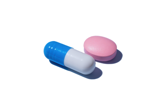 Vibrant blue and white capsule next to a soft pink tablet against a seamless backdrop creating a soothing contrast