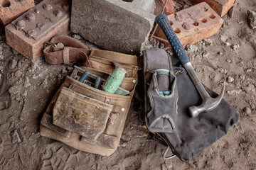 Close-up of tradesman's tool belt & tools on ground at building site