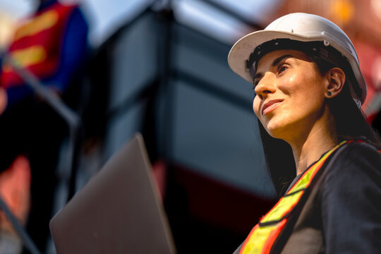 Two logistics workers man and woman discuss operations at a busy shipping container yard. successful coordination in freight, transportation, and supply chain operations