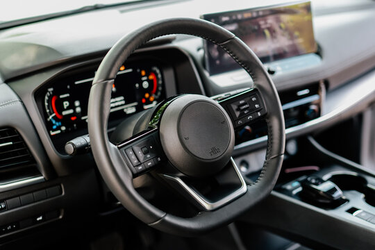 Fototapeta Close-up of a car steering wheel in a modern new car. The interior of a stylish new car. Concept of stylish design, shopping, and car parts.