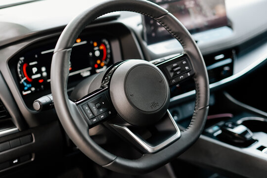 Concept of stylish design, shopping, and car parts. Close-up of a car steering wheel in a modern new car. The interior of a stylish new car. 