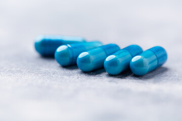 Amino acids capsules on bright wooden background. Soft focus. Close up. Copy space.	