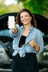 Car rental app. Happy woman showing an empty smartphone, smiling woman showing a place to copy a...