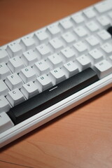 A wired 65% mechanical keyboard with a monochrome (black and white) theme on a wooden table.