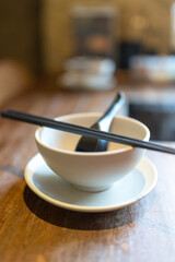 Table setting with ceramic, chopsticks and spoon on wood table