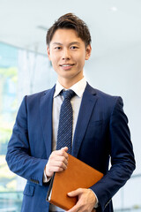 バインダーを持つ笑顔の男性ビジネスマン