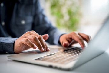 Close-up A hands man typing keyboard of laptop computer communicates on internet technology with...