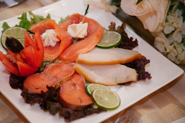 Delicious assortment of fresh seafood served on a white plate with vibrant garnishes at a restaurant event