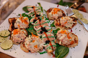 Delicious gourmet appetizers served on a white platter with vibrant garnishes during an elegant event