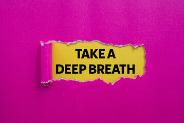 Take a deep breath message written on ripped torn pink paper on yellow background. Conceptual take a deep breath symbol. Copy space.