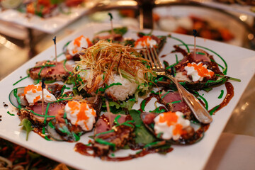 Elegant culinary presentation of gourmet sushi and hors d'oeuvres at a vibrant dining event in the evening