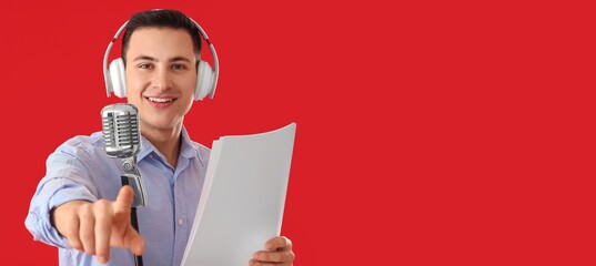Male radio presenter with microphone on red background with space for text