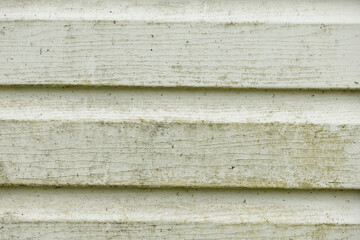 Abstract texture of white wooden panels with horizontal grooves. The surface shows signs of wear and dirt, creating a rustic appearance.