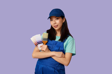 Female Asian painter with brush and paint color palettes on purple background