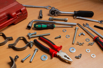 On the work table there are screwdrivers, wrenches, pliers, nuts, bolts and other tools