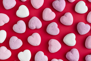Multicolor heart marshmallows on red background