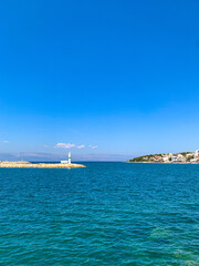 Fototapeta premium A small, lovely coastal and seaside town of Cesme on a summer blue sky and sunshine day, Izmir, Turkiye 