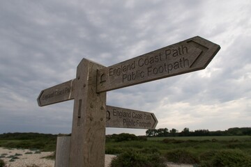 Wooden public footpath sign on England's coast path. Near Selsey, West Sussex