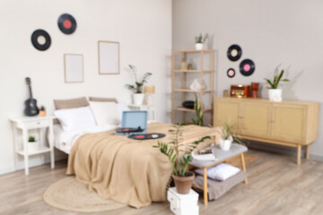 Blurred view of bedroom with plants, record player and vinyl disks