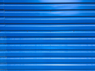 Obraz premium Metallic texture surface. Iron corrugated blue fence. Background material of tin wall. Blue corrugated metal texture surface wall or galvanized steel wall of industrial building