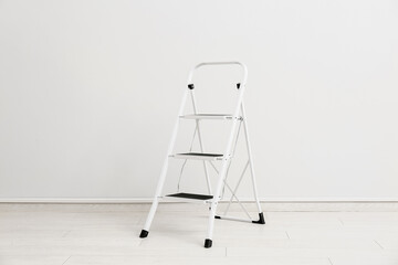 Maintenance ladder near white wall