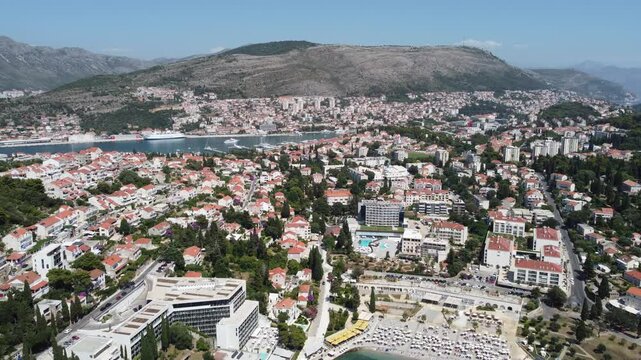 Dubrovnik, Croatia - July 01 2022 Aerial drone footage flying over residential buildings towards the mountains on a bright summer day near Uvala Lapad