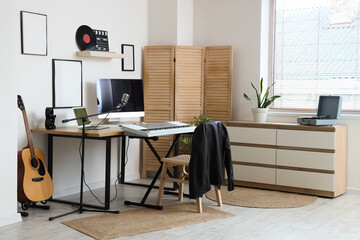 Interior of modern recording studio with workplace and musical instruments