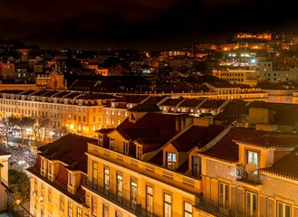 The night panorama of rooftops in Alfama district with the illuminated castle of São Jorge. 