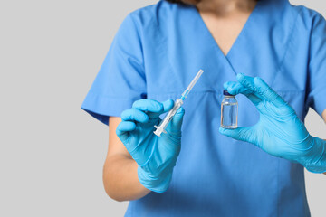 Female cardiologist with ampule and syringe on grey background, closeup