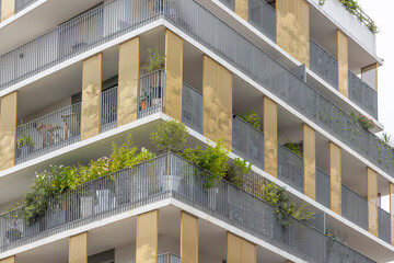 Modern building facade with balconies and plants growing in Montpellier, France