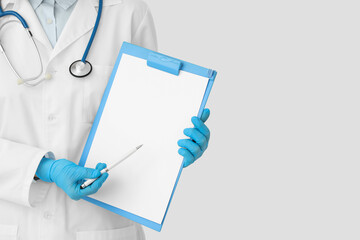Female cardiologist with stethoscope pointing at clipboard on white background, closeup