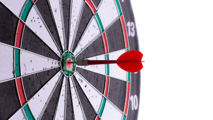 Red dart hitting bullseye on dartboard, close up isolated on white background. Target accuracy, goal achievement, precision, success concept, focus strategy, perfect aim in darts game.
