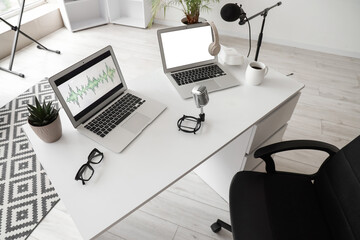 Podcaster's workplace with laptops and microphones in studio