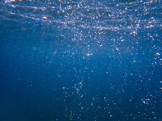 The sun shines through water, casting mottled light and shadow, intertwined with countless bubbles...