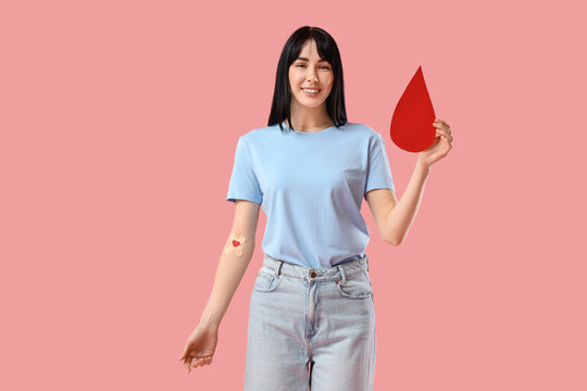 Female blood donor with medical patches and paper drop on pink background - Powered by Adobe