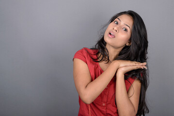 Naklejka premium A confident young woman dressed casually in a red top and blue jeans, posing with jovial facial expressions and emotions