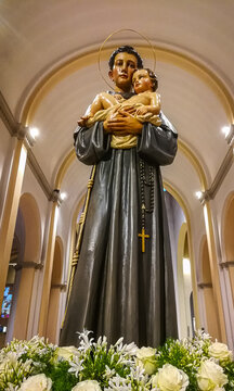 Background with wooden statue of Saint Anthony with baby Jesus