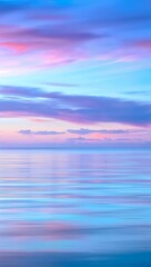 Obraz premium Pastel hues paint the tranquil ocean at dawn, a soft pink and lavender sky reflected in the calm waters